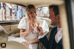 Outside Wheldrake Church, a toast is given by the bride and groom seated in the back of a vintage limo.